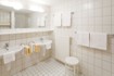 Bad mit Dusche und zwei Waschbecken sowie WC