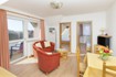 Sitzecke mit Zweier-Sofa, Sessel und Sat-TV (Blick zum Balkon und die beiden Schlafzimmer
