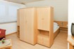 Großer Schrank als Raumteiler, 
dahinter das Doppelbett